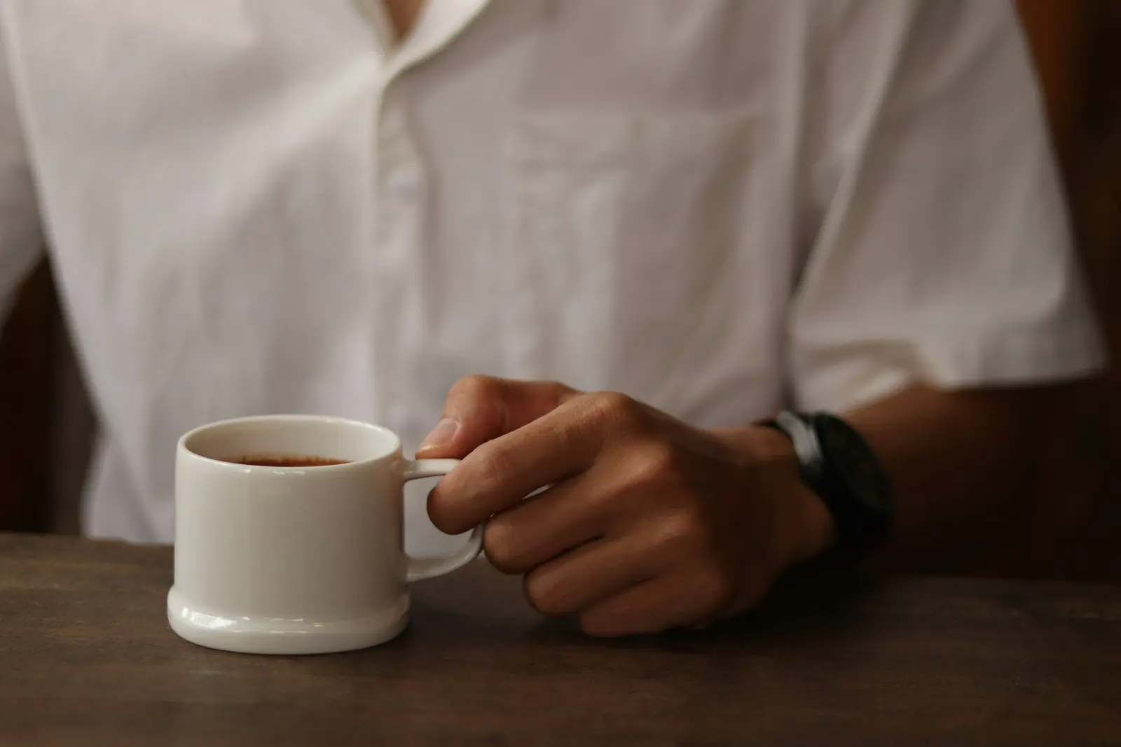 A person holding a cup of coffee at a cafe in Da Nang.