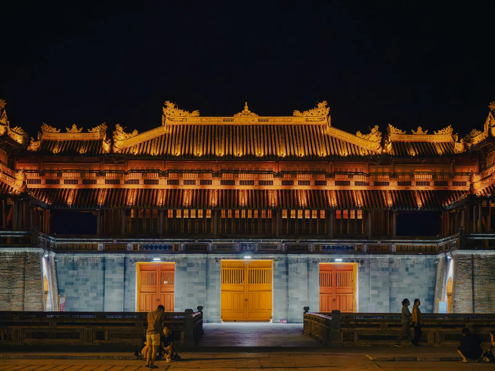 The illuminated entrance to the Imperial City in Hue at night.