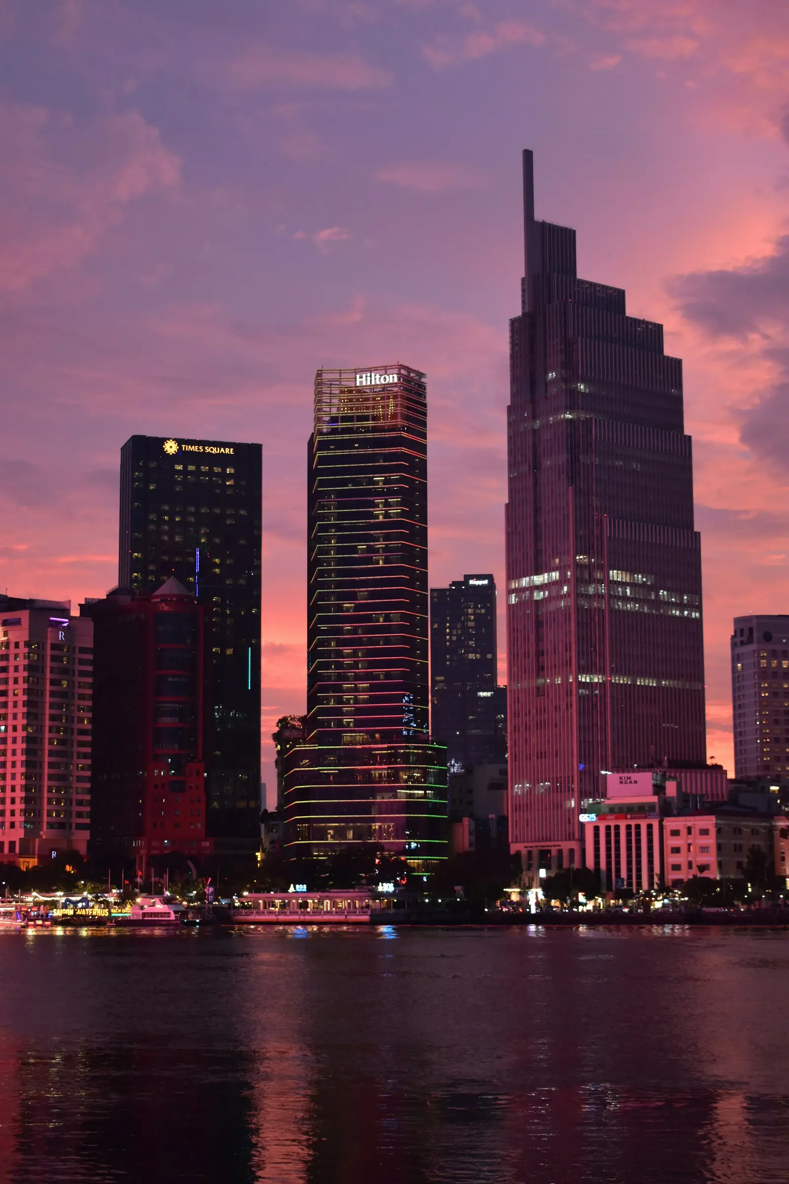 Ho Chi Minh City skyline reflected in the Saigon River at sunset.